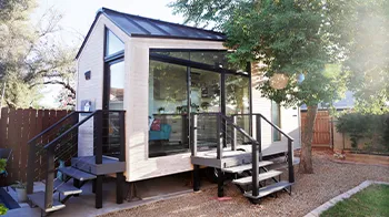 Tall glass windows front a small home